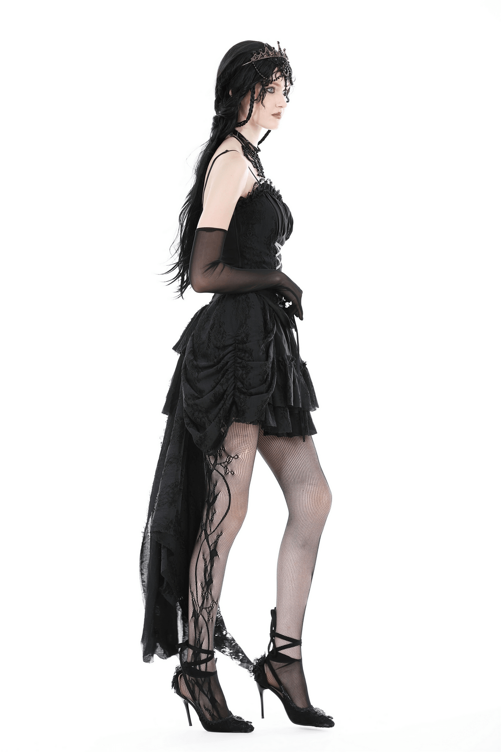 Dark gothic model in lace-up black bustier corset with dramatic skirt and stylish heels.