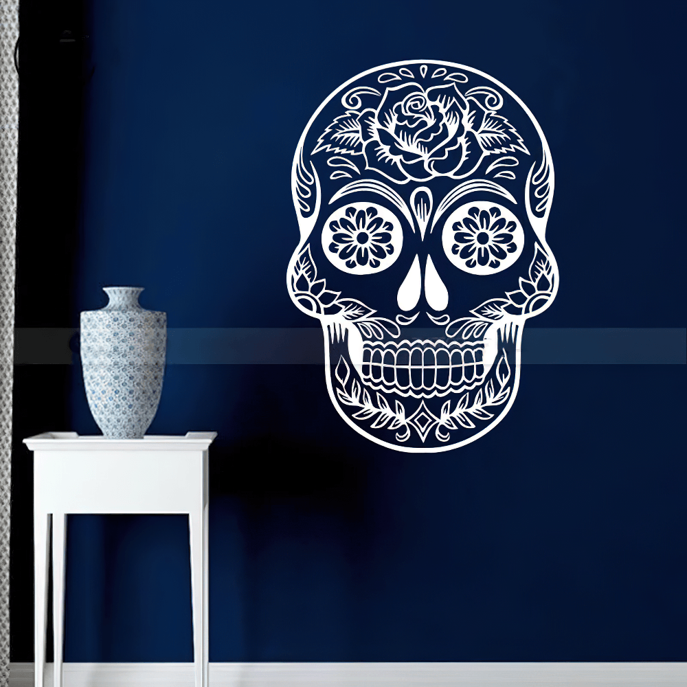 Floral Sugar Skull Vinyl Wall Sticker for Gothic Decor on a blue wall beside a vase and white furniture.
