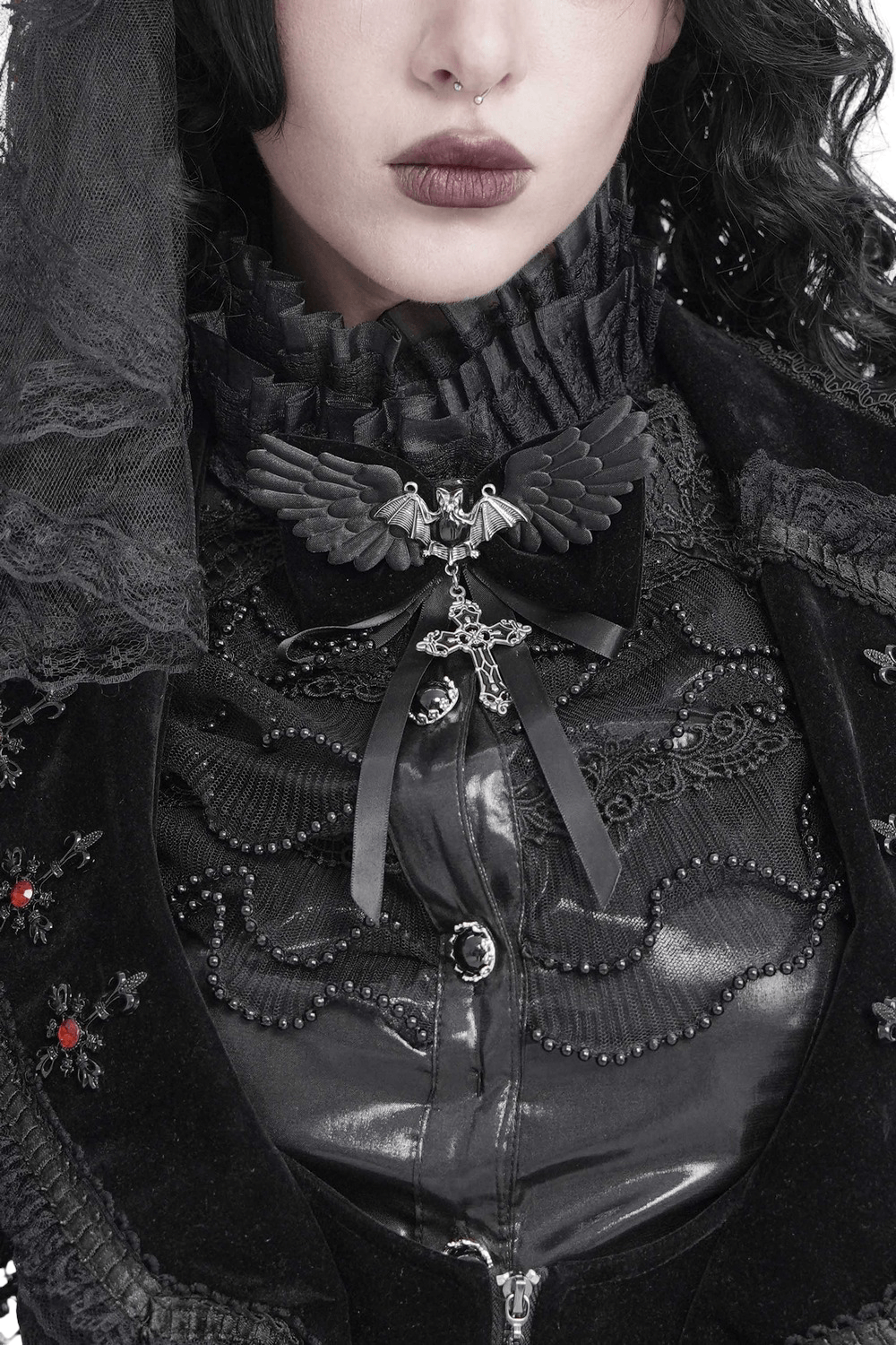 Goth Bat Wing Bow Brooch with Cross Pendant and Ribbon featured on a gothic outfit with intricate black detailing.