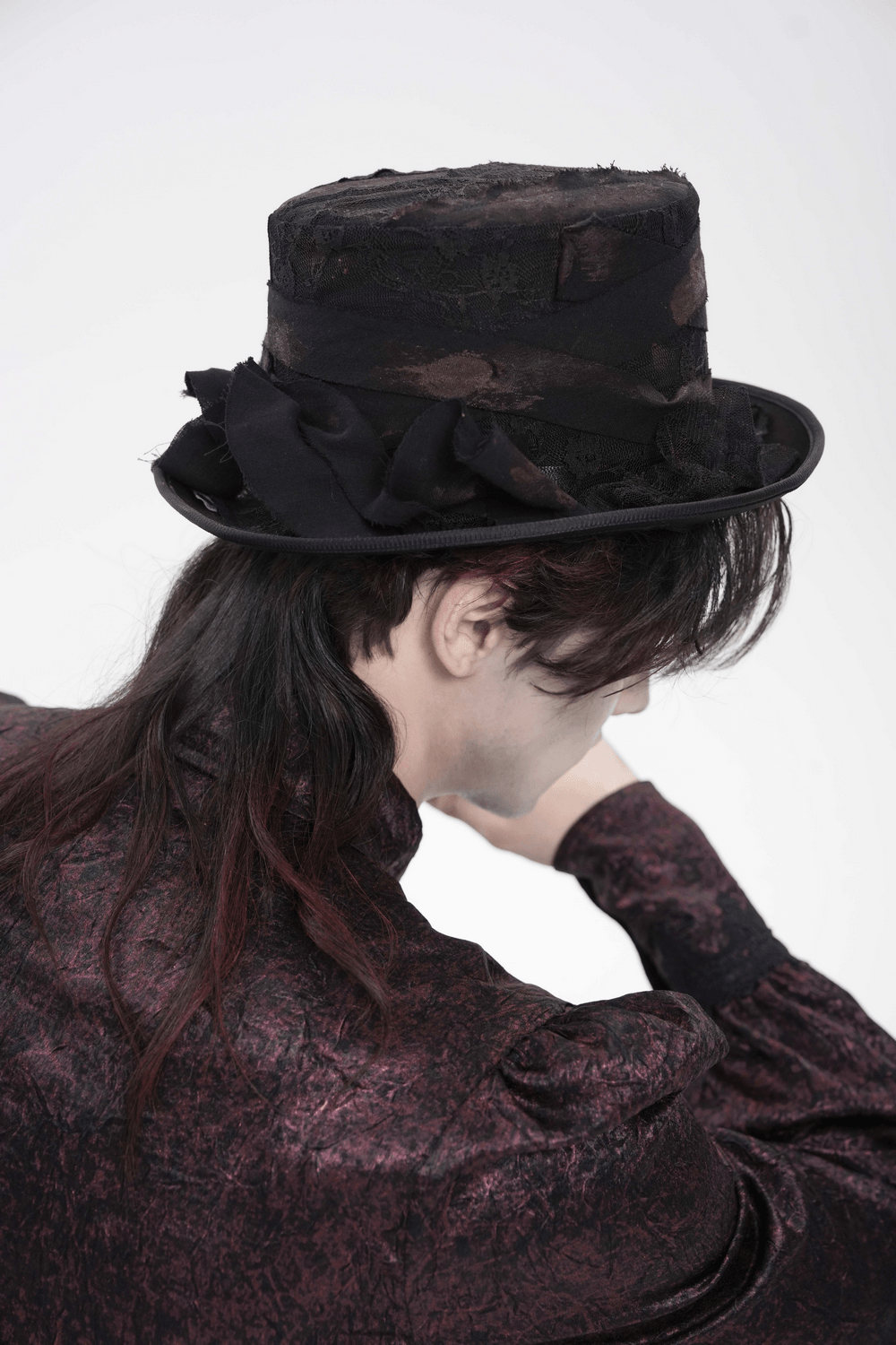 Gothic Distressed Top Hat With Vintage Lace Trim worn by a figure in a dark outfit, showcasing its unique distressed design.
