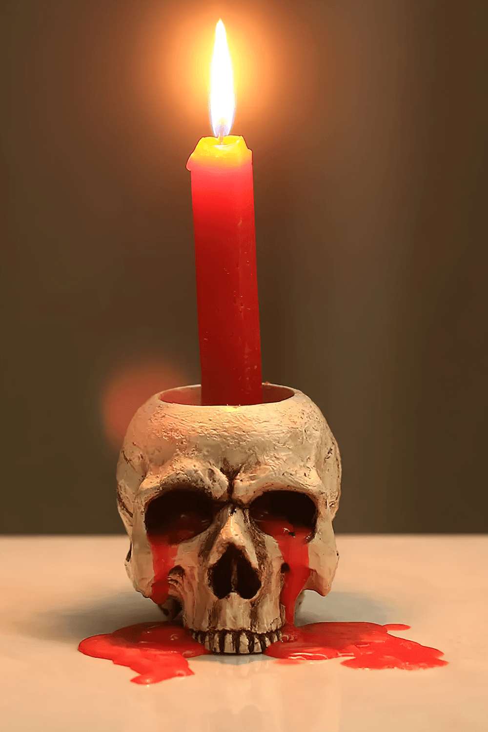 Gothic Skull Tealight Holder for Tabletop Decor with a red candle and dripping wax, perfect for spooky party ambiance.