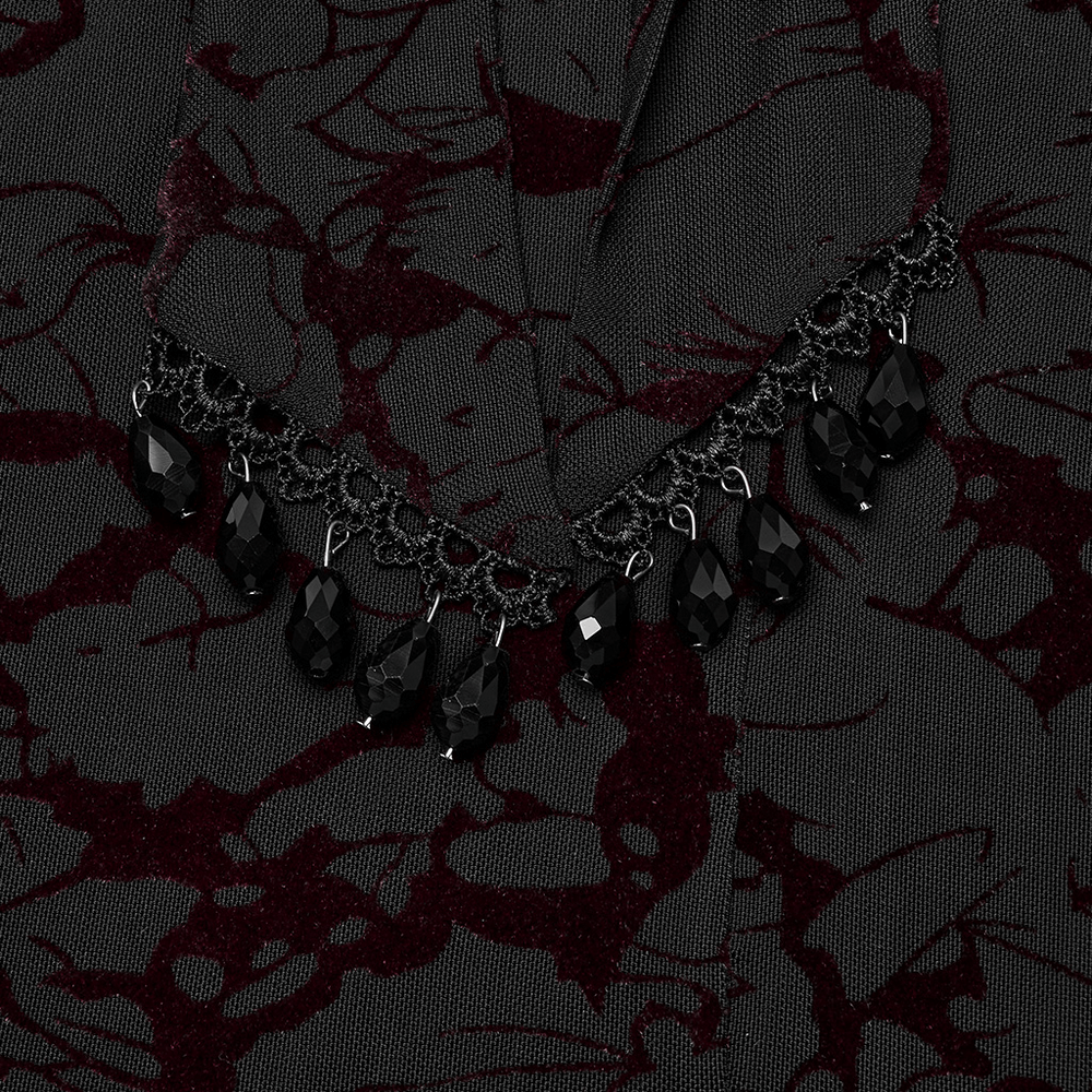 Close-up of Gothic V-neck detail with black lace and water droplet pendants on black dress.