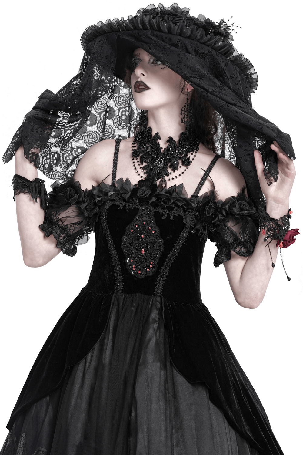 Gothic Victorian lace mourning hat with floral details and mesh veil worn by model in elegant black dress.