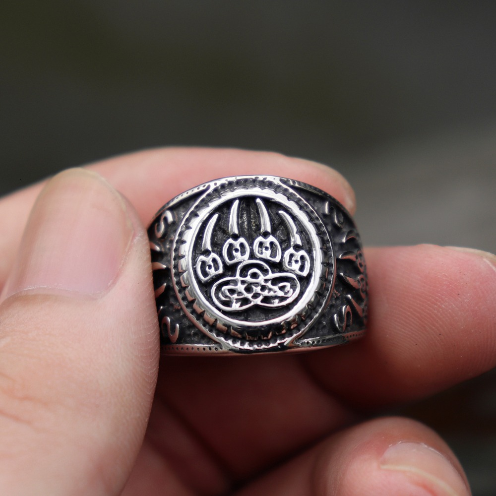 Bear Paw stainless steel ring with Celtic knot design held in hand, unisex jewelry for stylish individuals.