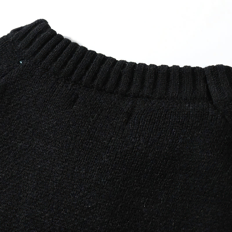 Close-up of the collar of a black retro sweater, showcasing its soft texture and casual style.